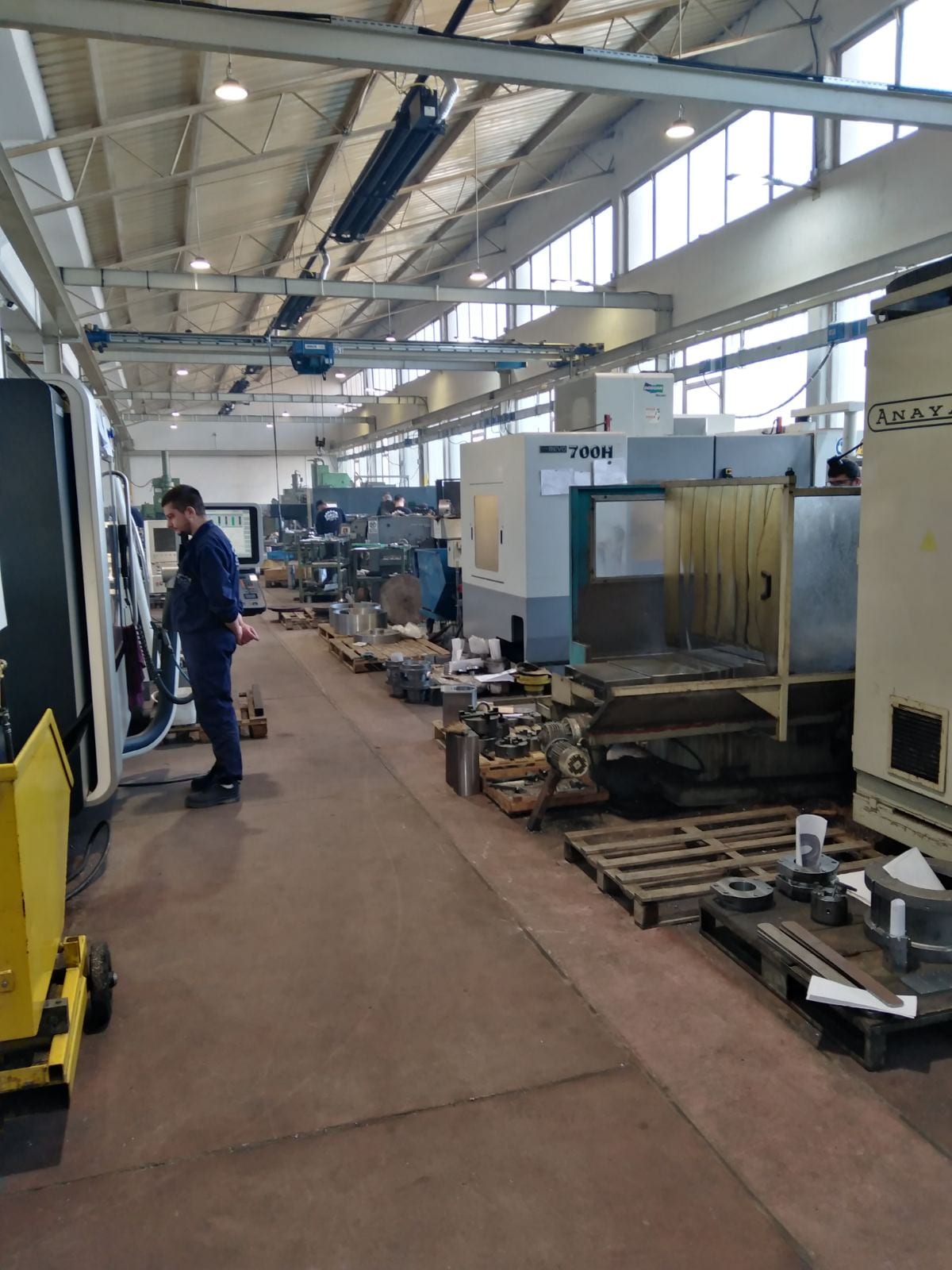 Red CNC obradnih centara u hali, sa paletama pripremljenih delova