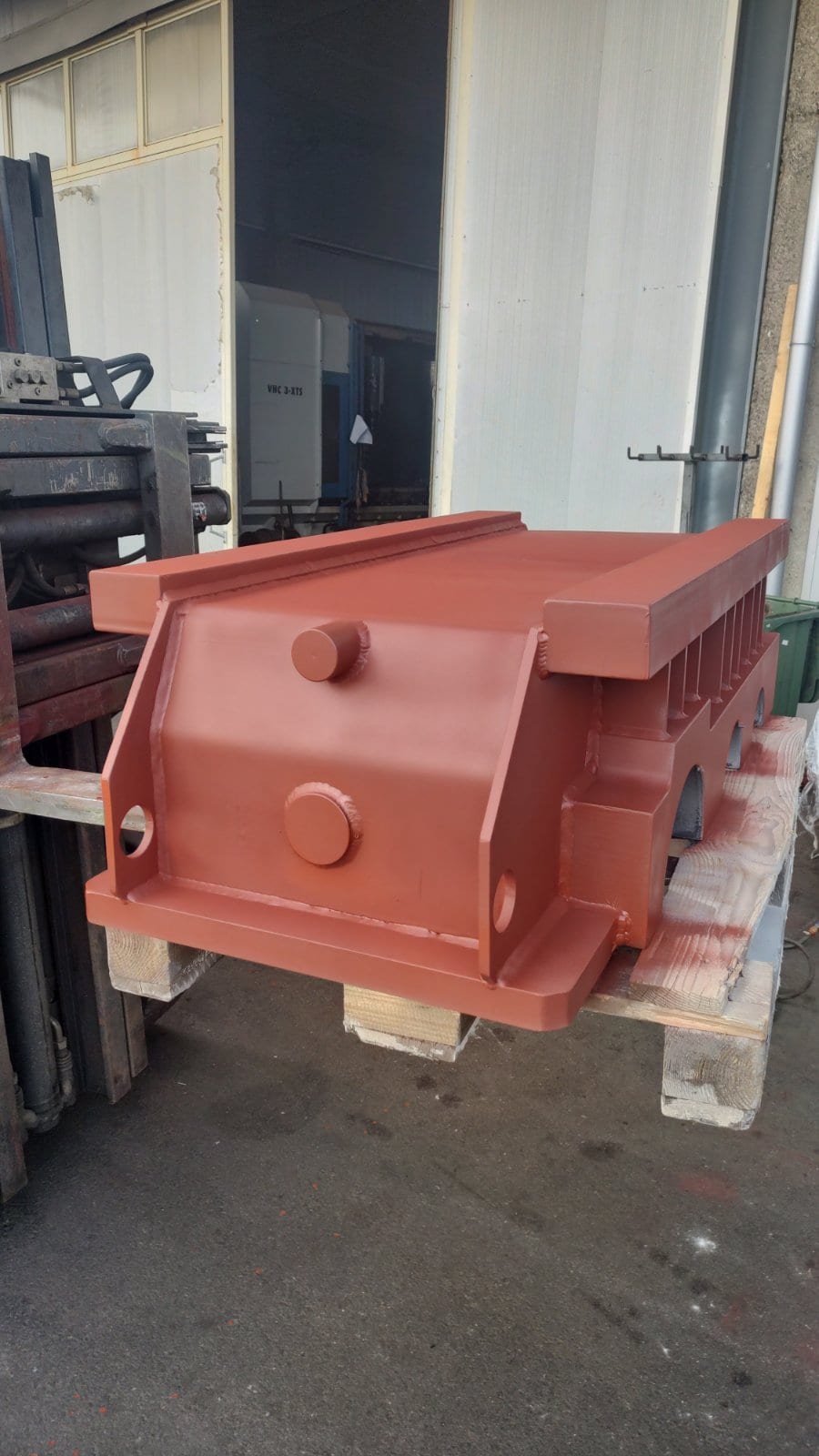 Welded gearbox housing in red primer, outside the hall entrance