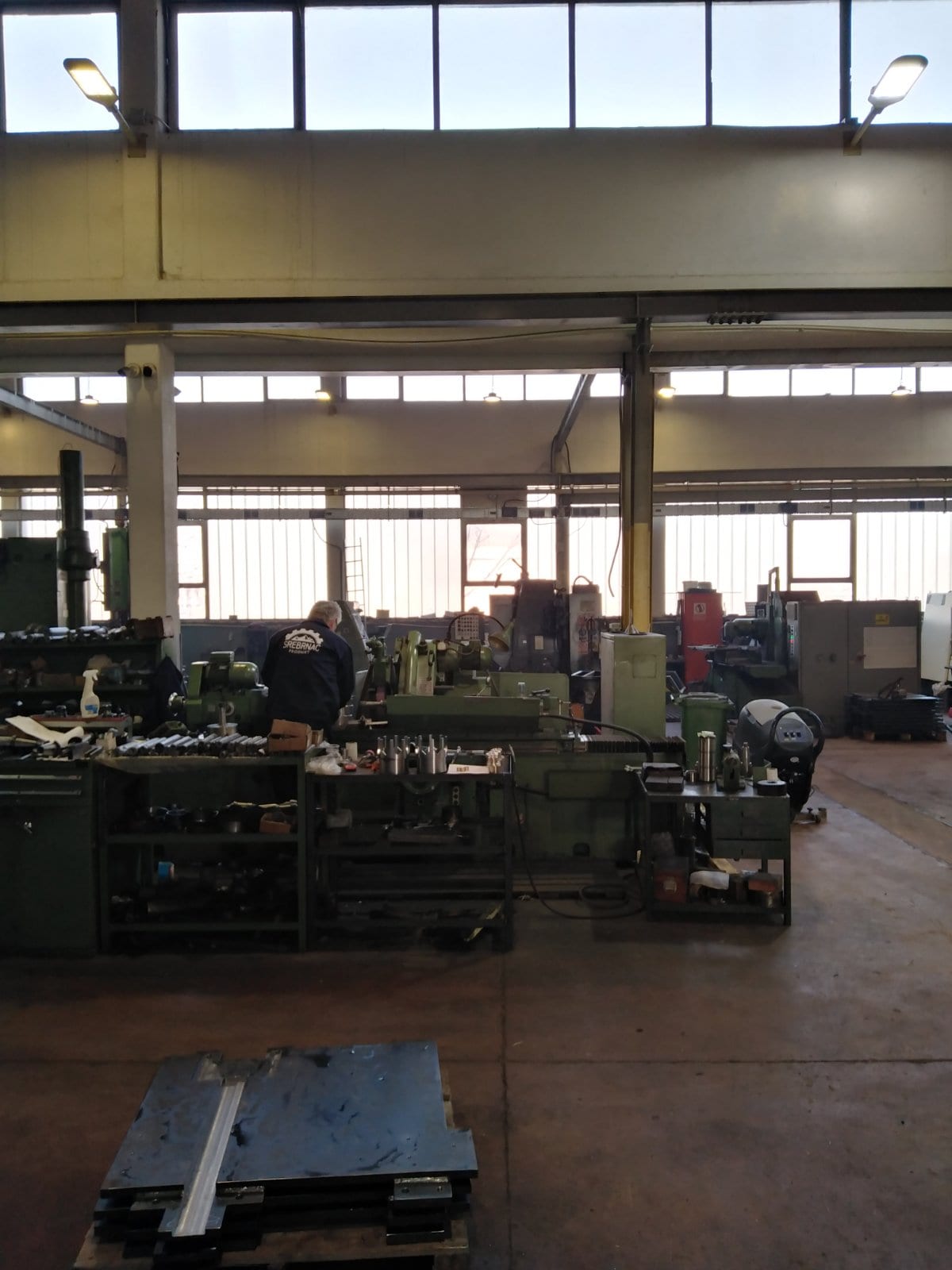 Work bench with measuring and cutting tools, machines behind